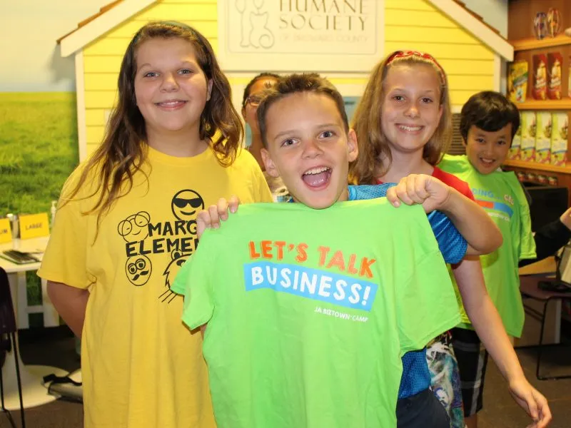 Students showing off their shirts at a JA BizTown summer camp